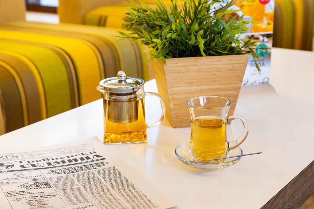 特里亚夫纳赞美酒店的坐在桌子上边看报纸的一杯蜂蜜罐