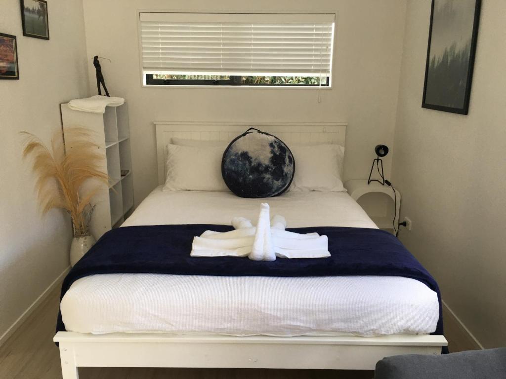 奥克兰West Auckland Delight Stay的一间卧室配有一张床,床上有毛巾