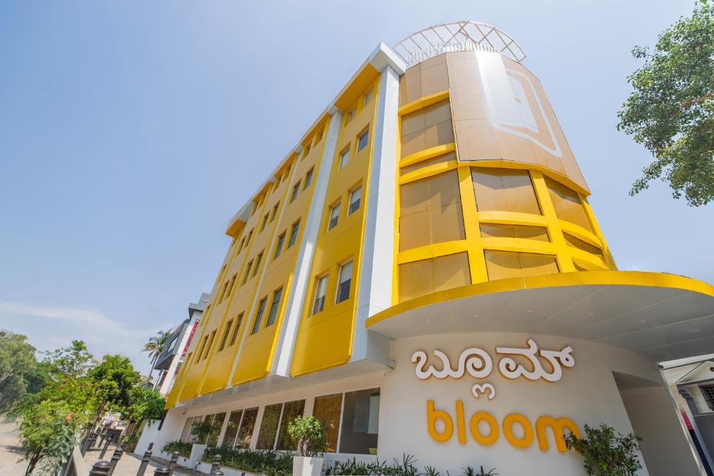 班加罗尔Bloom Hotel - Richmond Road的黄色的建筑,上面有钟