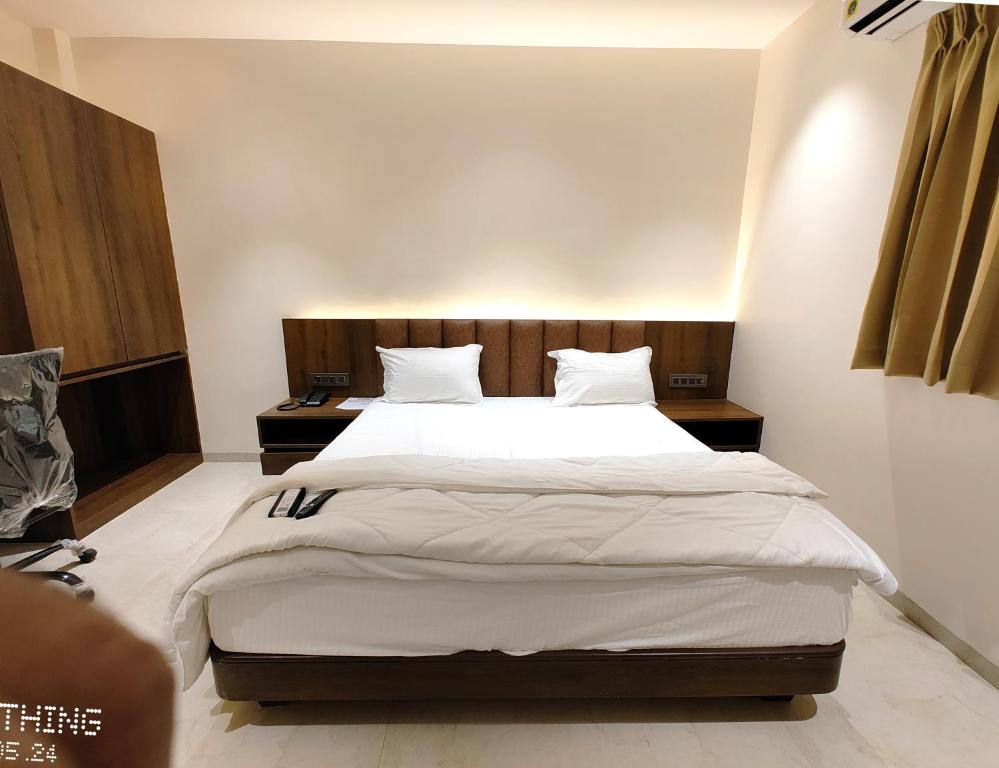 楠代德HOTEL 3T WORLD的卧室配有一张带白色床单和枕头的大床。