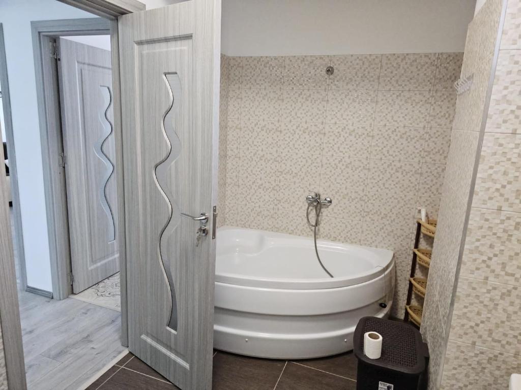 拉姆尼库沃尔恰Apartament edy的带浴缸和卫生间的浴室。