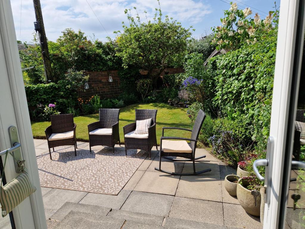 普雷斯蒂克Troon Open golf - Private house with garden in central Prestwick的一组椅子坐在庭院里