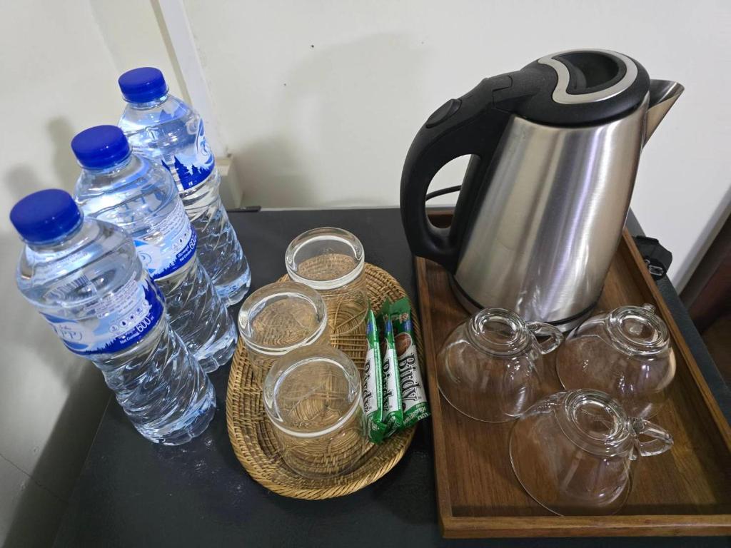 大城Chanida home的茶壶、茶杯和桌子上的瓶装水