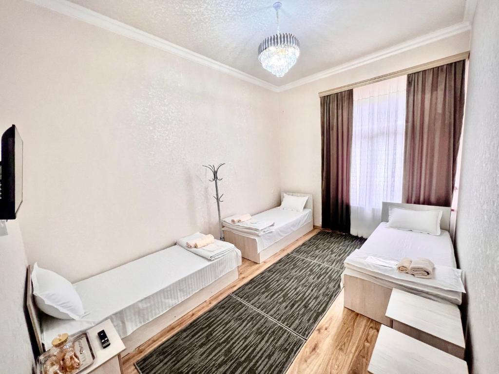 撒马尔罕MrShox Hostel的客房设有两张床和窗户。