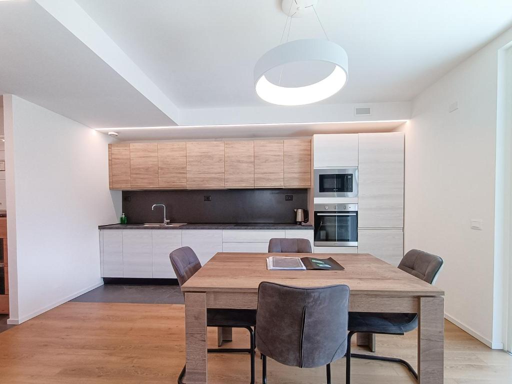 马累Suite Svaizer con giardino privato的厨房以及带木桌和椅子的用餐室。