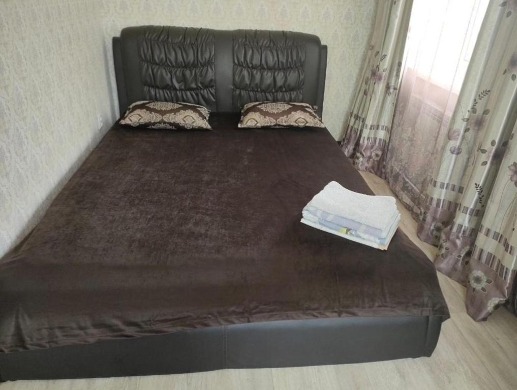 阿克托比Уютная двухкомнатная квартира в Актобе的卧室内的一张床位,配有黑色床架