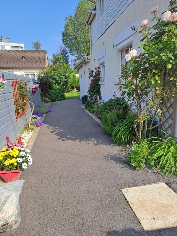 蒙圣埃尼昂Gîtes Les Lucioles的院子内鲜花盛开的房子的车道