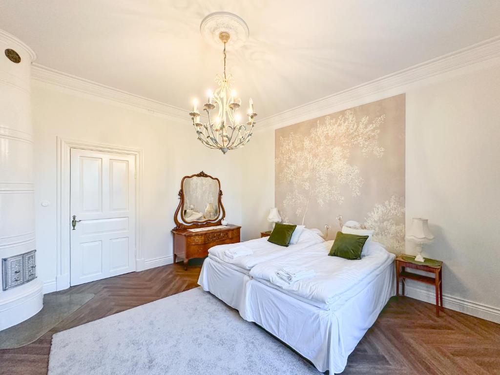 玛丽港Strandnäs Gård的白色卧室配有一张床和一个吊灯