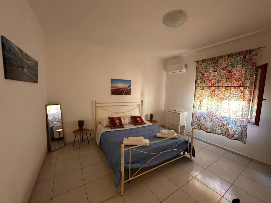 法维尼亚纳A Due Passi dal Centro的一间卧室配有一张带蓝色床单的床和一扇窗户。