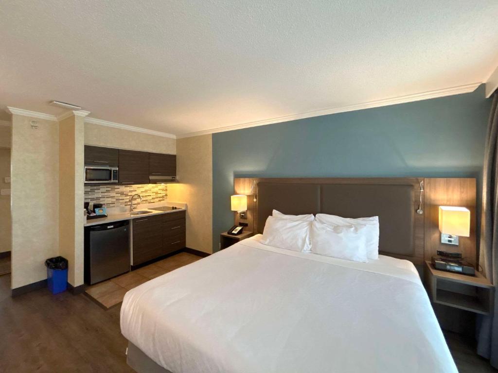 温哥华Grand Park Hotel & Suites Downtown Vancouver, Ascend Hotel Collection的酒店客房设有一张大床和一个厨房。