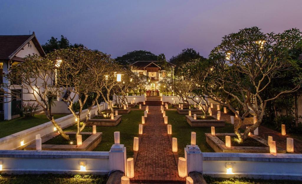 琅勃拉邦The Grand Luang Prabang, Affiliated by Meliá的花园,晚上有树木和灯光