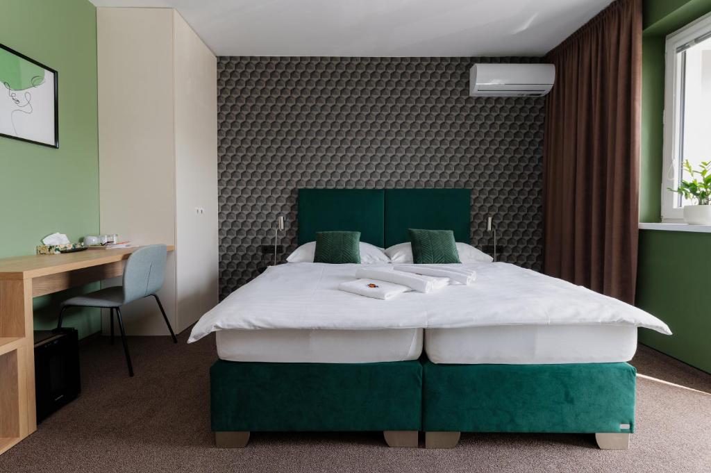 尼特拉Penzion Tofi的卧室配有绿色和白色的床和书桌。