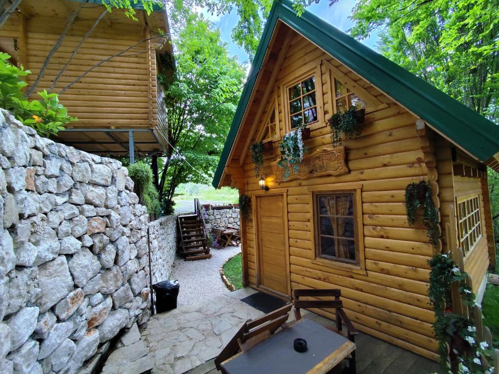 采蒂涅Brvnara Fairy Tale的小木屋设有石墙和庭院。