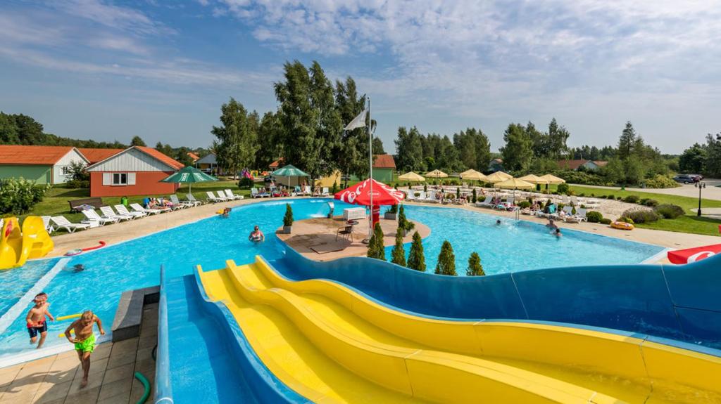 韦巴Holiday Park Kacze Stawy的水上公园里一个带滑梯的大型游泳池