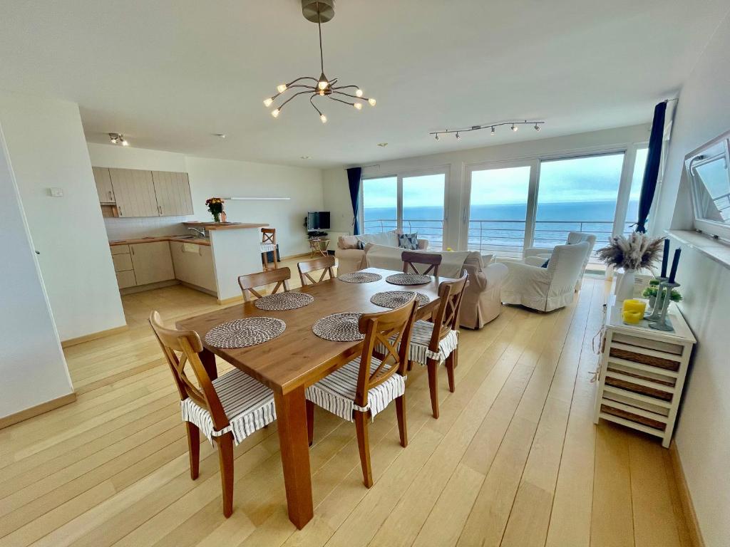 布兰肯贝赫3BR Zeedijk apartment Ocean View的用餐室以及带桌椅的起居室。