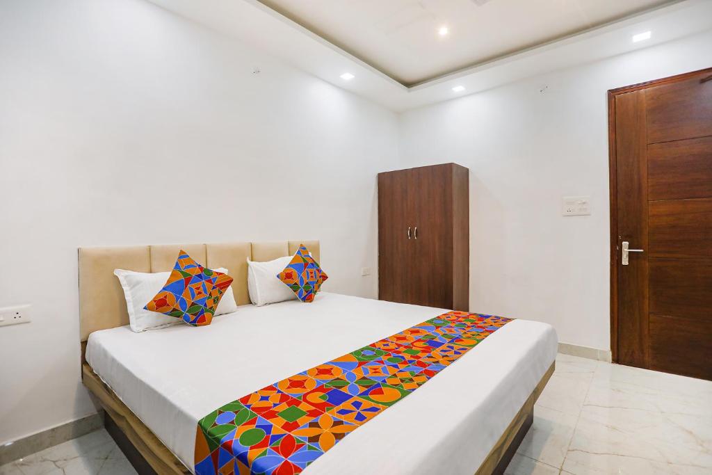 瓦拉纳西FabHotel JP Villa的一间卧室配有一张带彩色毯子的床