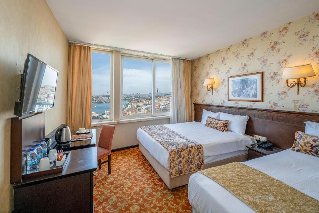伊斯坦布尔Pera Rose Hotel - Taksim Pera的酒店客房设有两张床和电视。