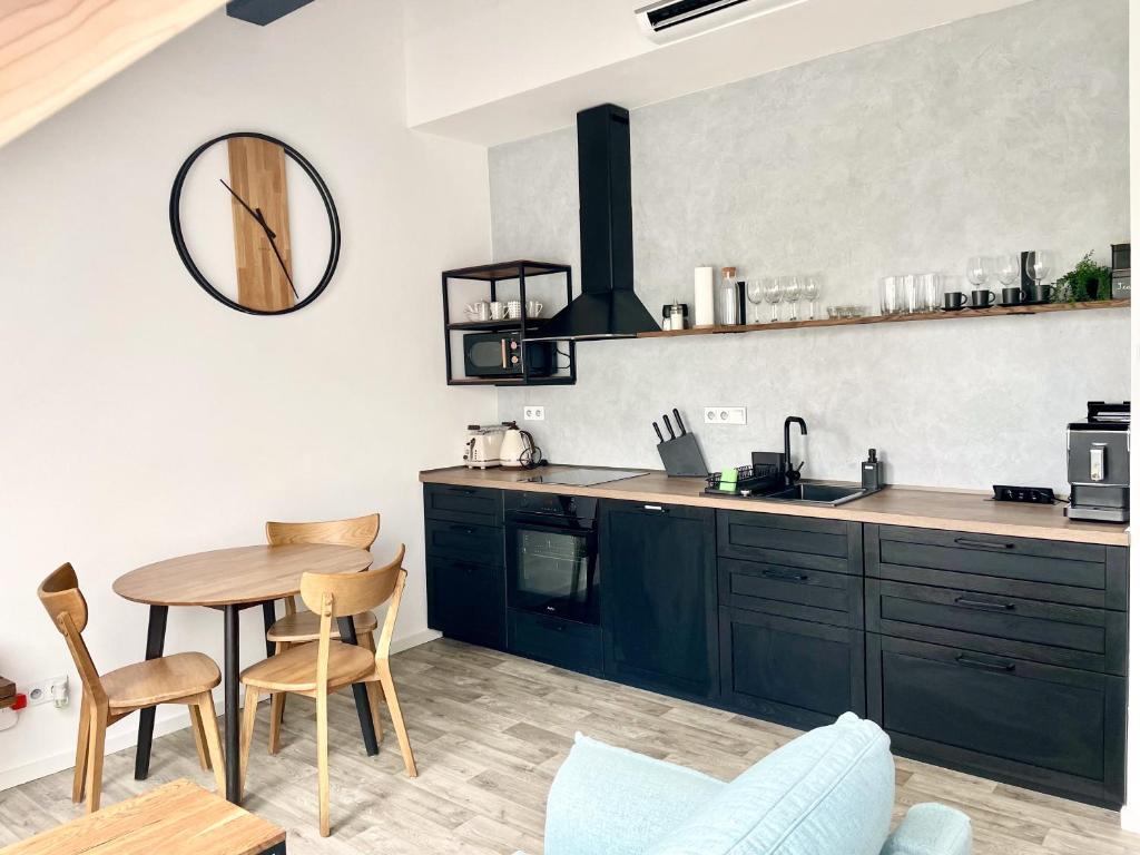 米库洛夫Apartmán Bella的厨房配有黑色橱柜、桌子和镜子