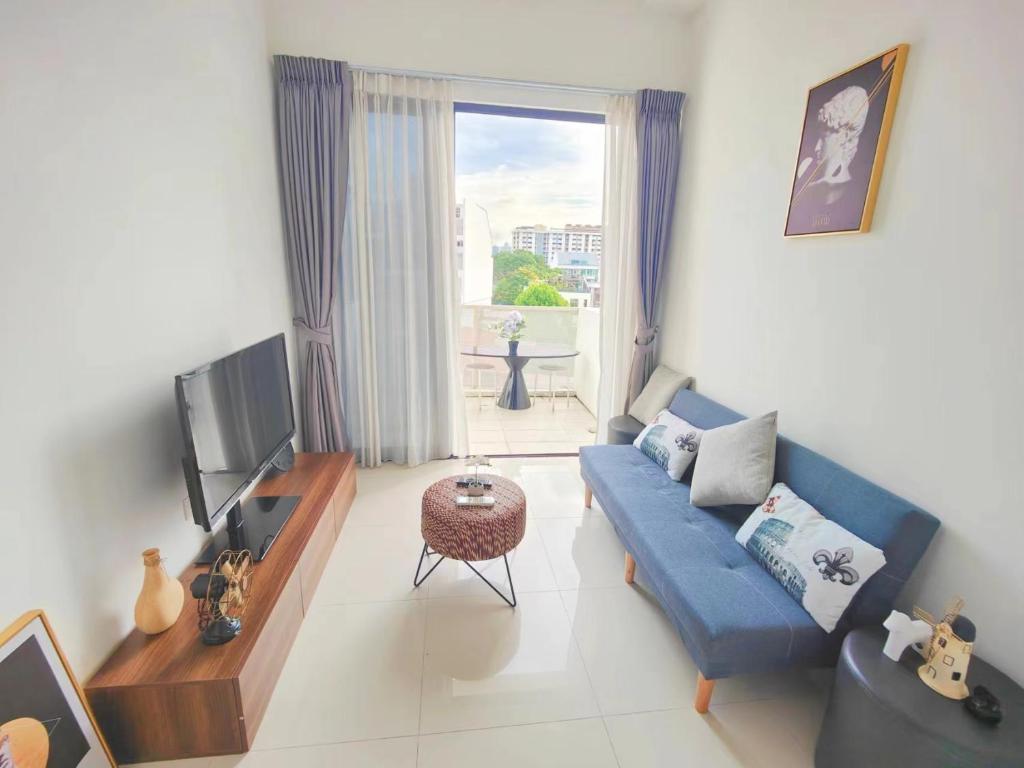 新加坡Centralize Stylish Loft Apartment Beside Mrt 摩登小屋的客厅配有蓝色的沙发和电视