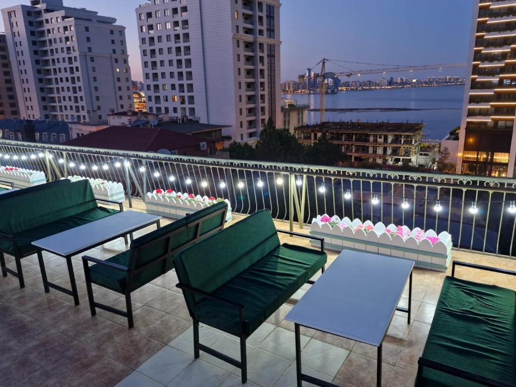 巴库Nur Hotel Sea View的屋顶露台配有桌椅和灯光