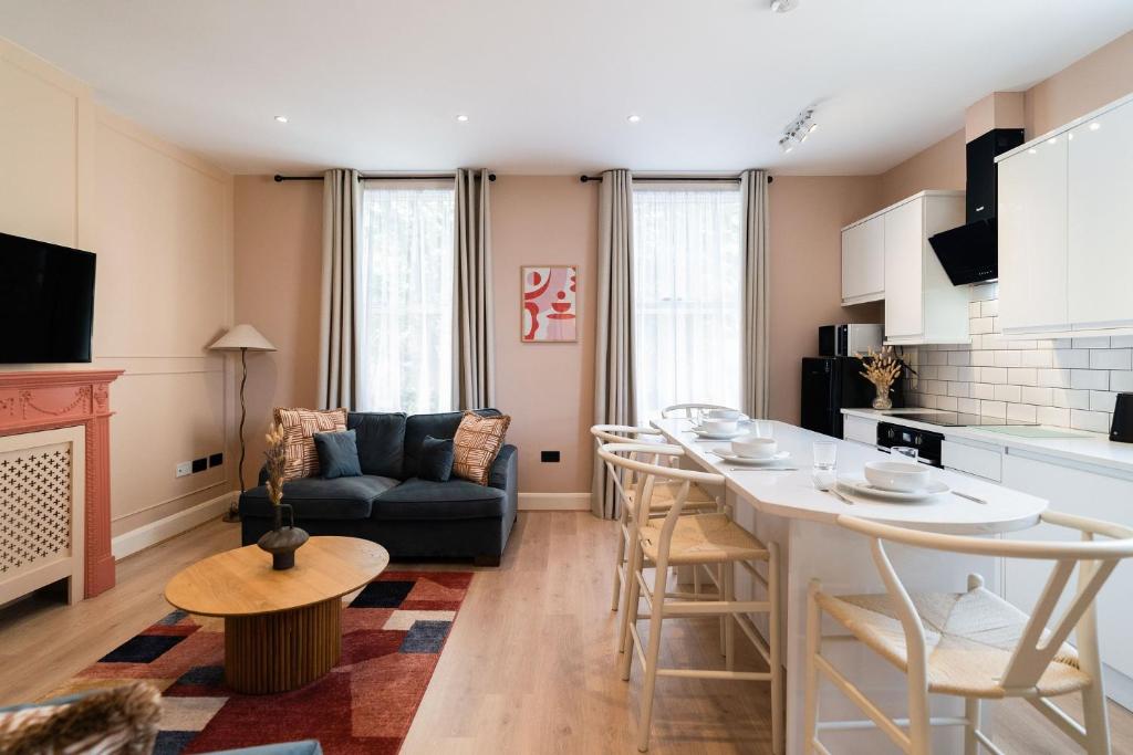 伦敦Lamington Apartments - Hammersmith的厨房以及带桌子和沙发的客厅。