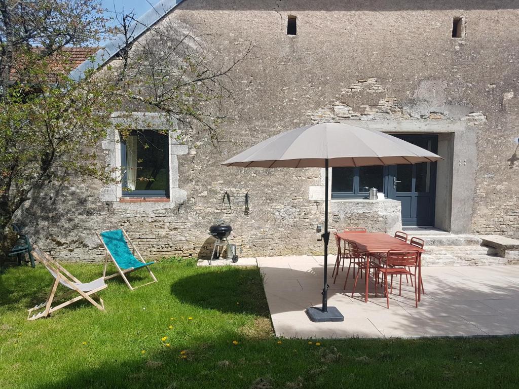 Sorans-lès-BreureyLe Cottage的院子里的桌子和椅子以及雨伞
