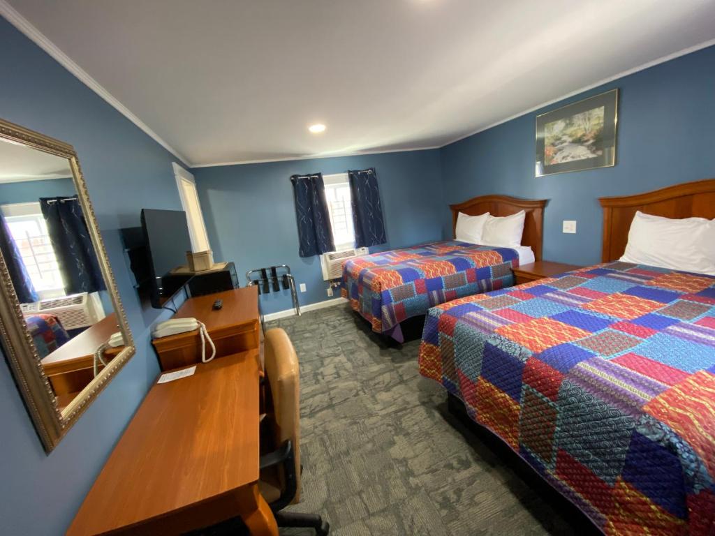 ClaremontRoyal Inn的酒店客房,设有两张床和镜子