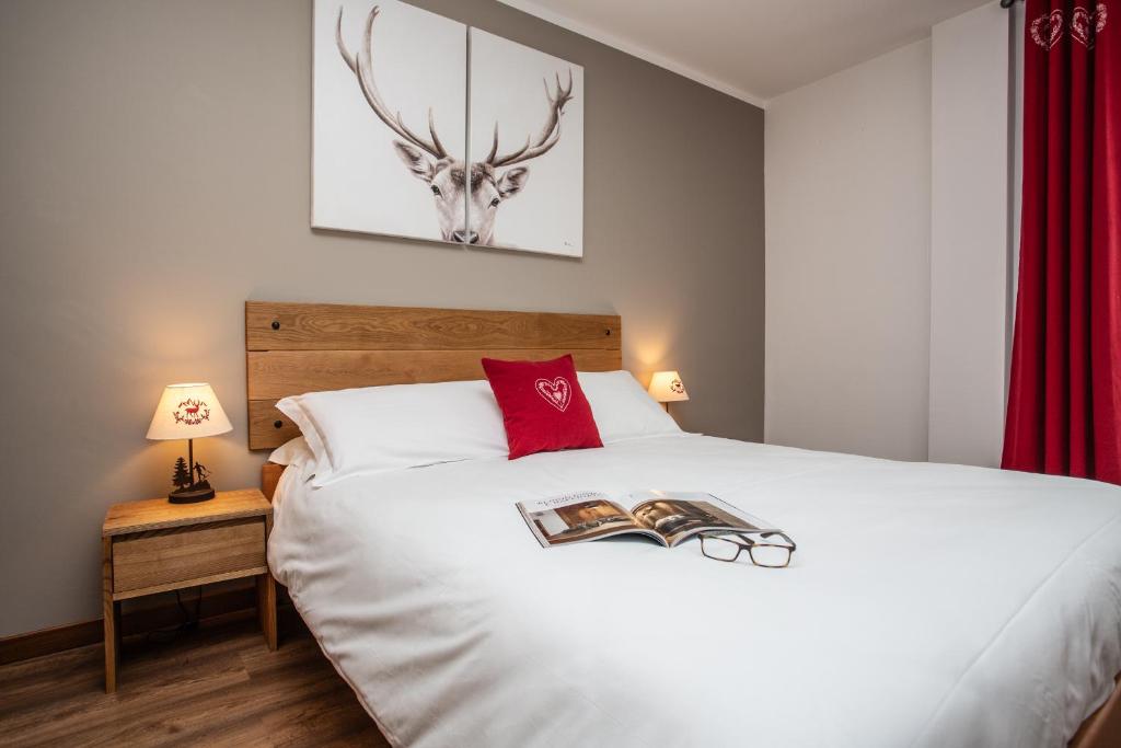 瓦托内切Apartments Les Crouses的卧室配有白色的床,上面有鹿头