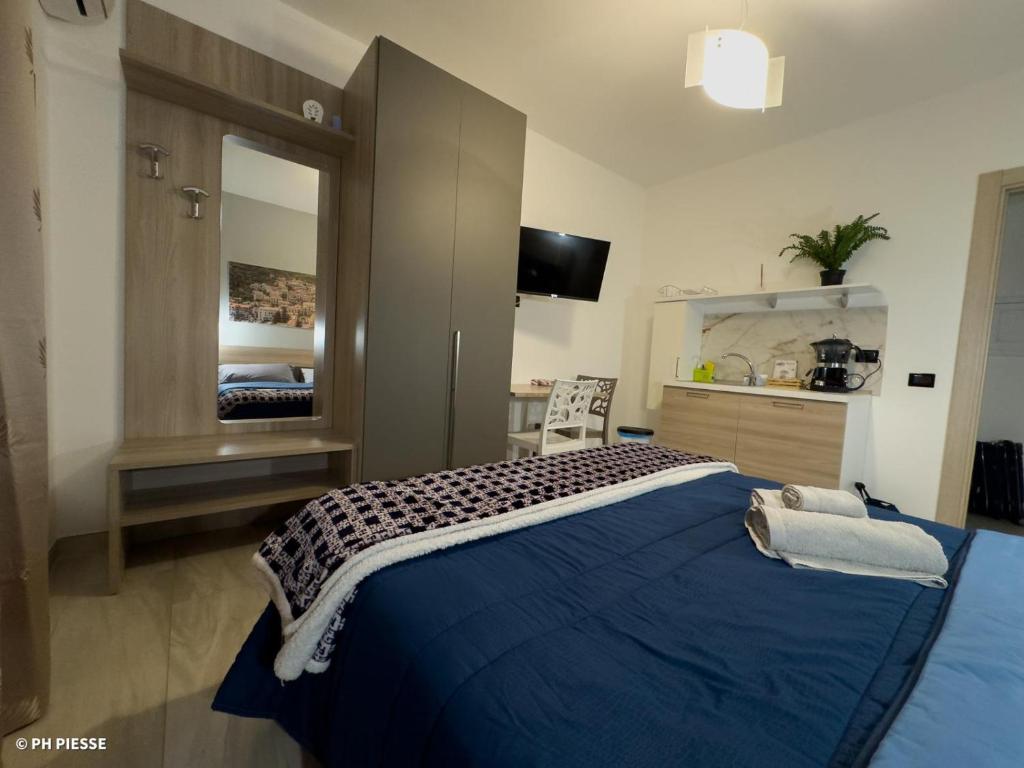 帕奥拉B&B Alba Chiara的一间卧室配有蓝色的床和镜子