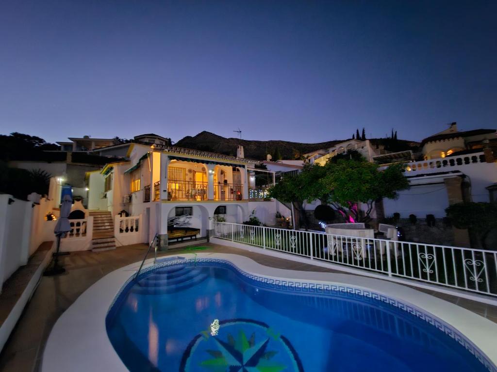 阿罗约德拉迷雅Villa Tony - Benalmádena的游泳池在晚上在房子的阳台上
