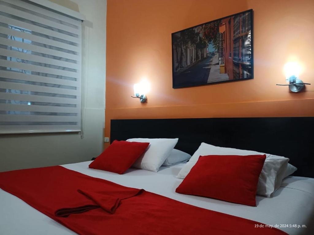 波帕扬Hotel La Herreria Colonial的一间卧室配有红色和白色枕头的床
