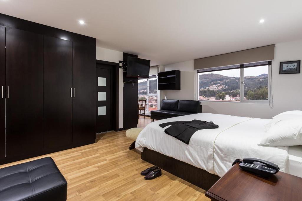 昆卡Gaviota Apartments & Suites的一间卧室配有一张床、一张书桌和一个窗户。