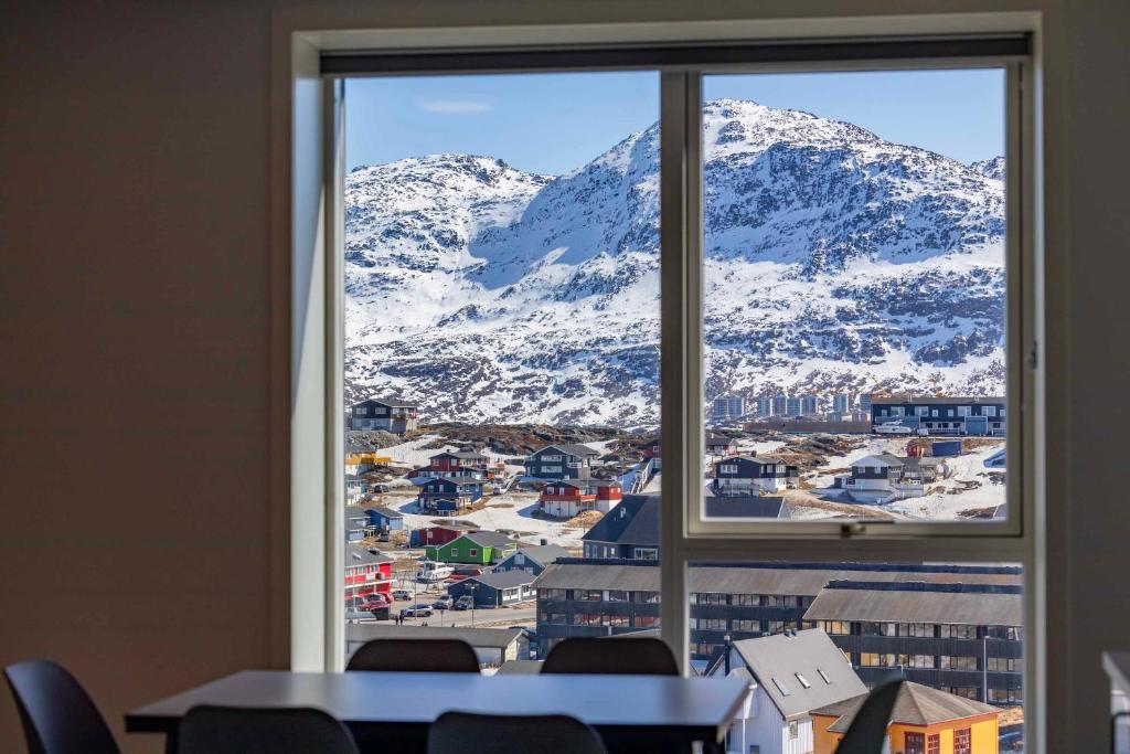 努克Hotel Aurora Apartments的从窗户可欣赏到白雪 ⁇ 的山景
