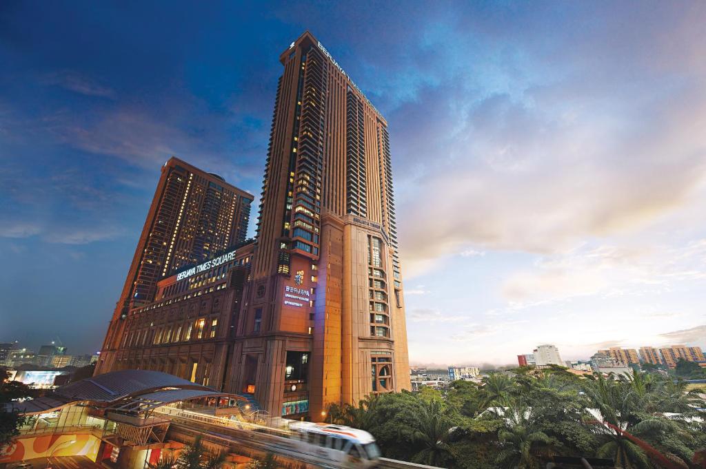 吉隆坡Berjaya Times Square Hotel, Kuala Lumpur的前面有一辆公共汽车的高层建筑