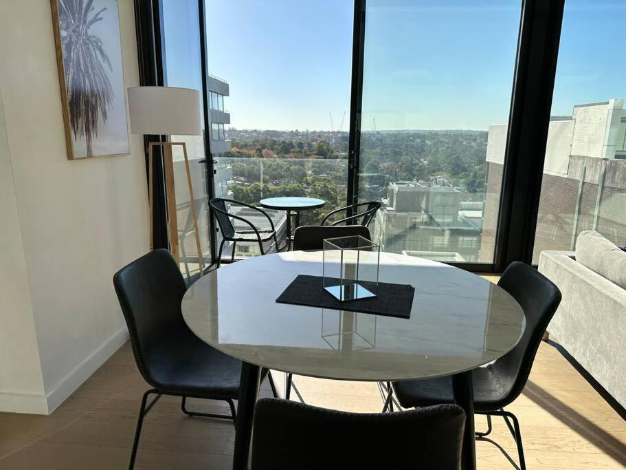悉尼Stunning Apartment ATC10610的配有大窗户的客房内的桌椅