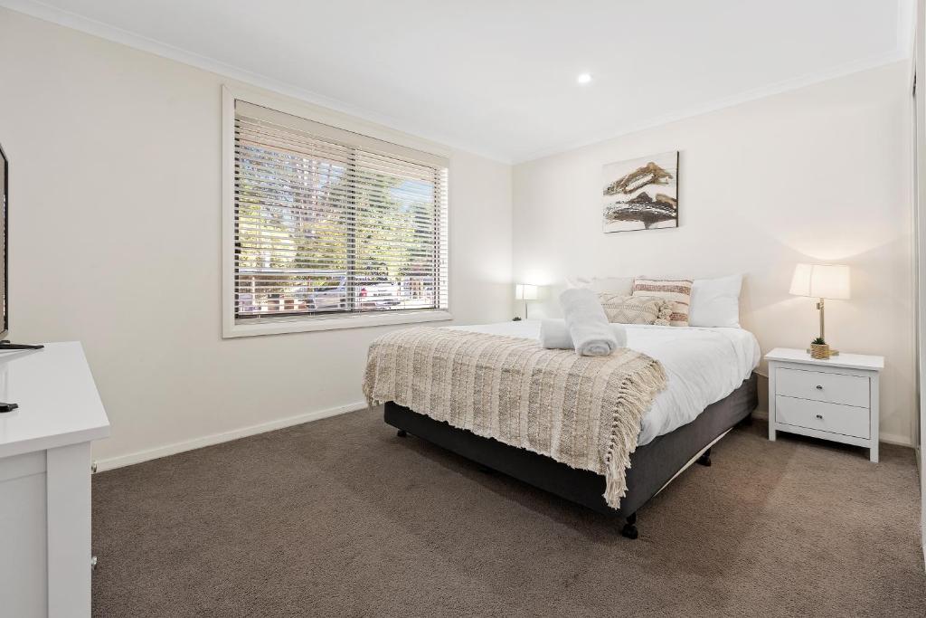布赖特Tasman Holiday Parks - South Bright的白色的卧室设有床和窗户