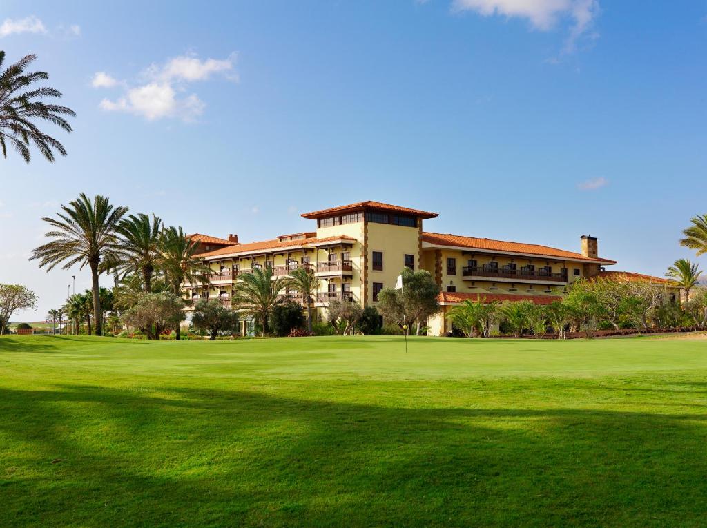 卡勒达德福斯特Elba Palace Golf Boutique Hotel - Adults Only的从高尔夫绿色地带欣赏到度假村的景色