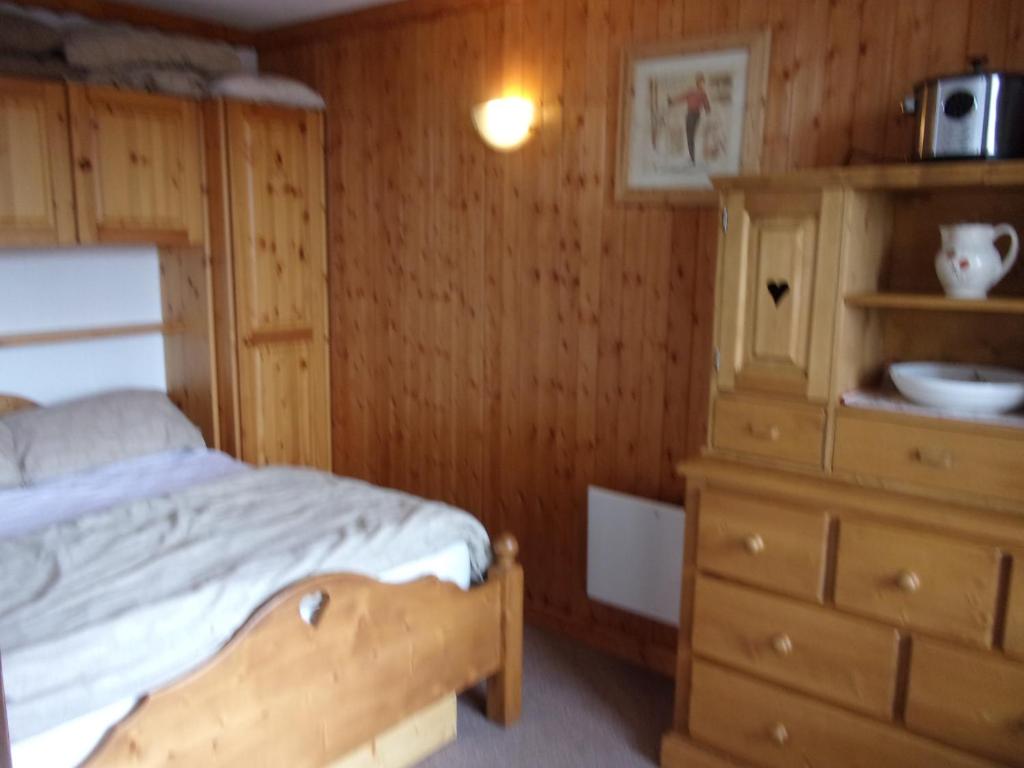 里蒙纽耶La Villaret的一间卧室配有一张床和一个木制梳妆台