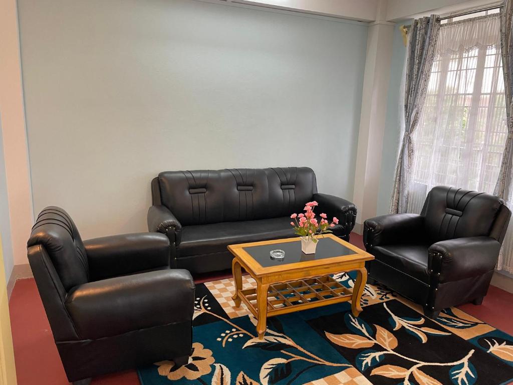 西隆Keeon Private Room Top的客厅配有黑色皮革家具和咖啡桌