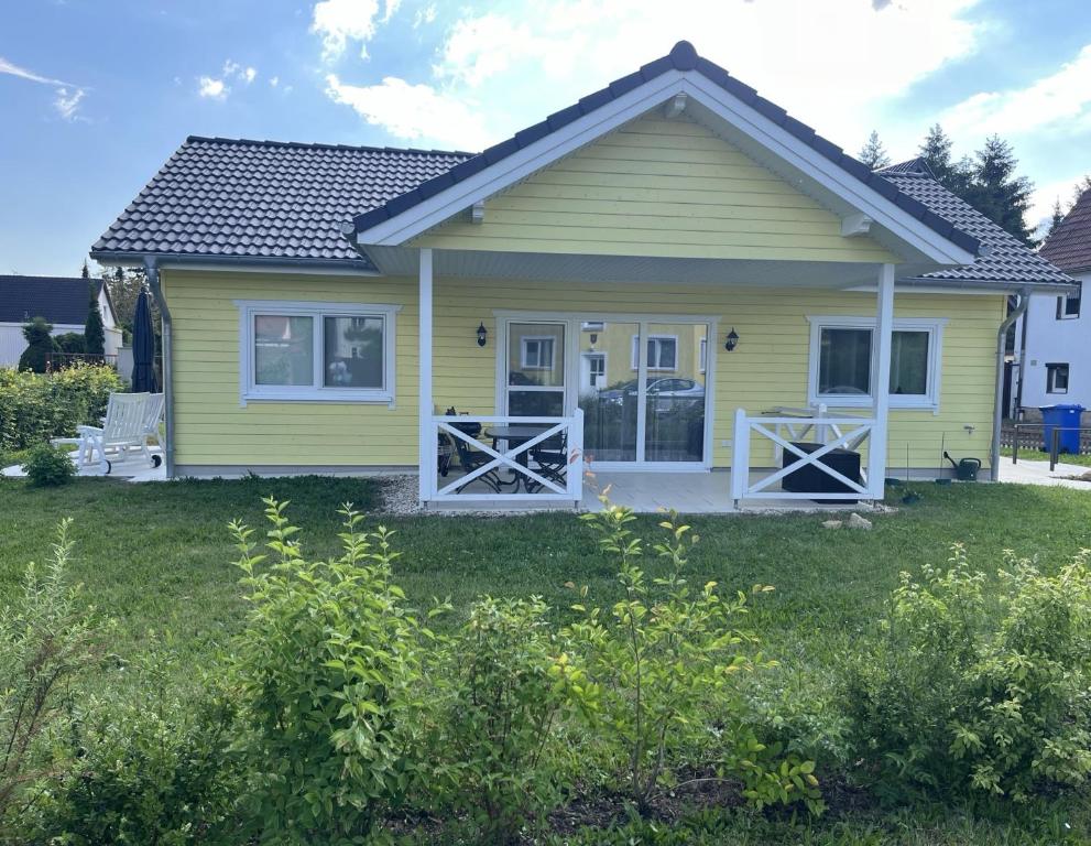 萨勒河畔瑙姆堡Chalet Altalmrich的院子内有两扇门的黄色房子