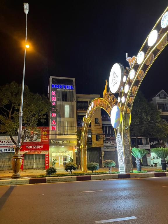 邦美蜀Khách sạn Khang An Buôn Ma Thuột的夜街与有钟的建筑