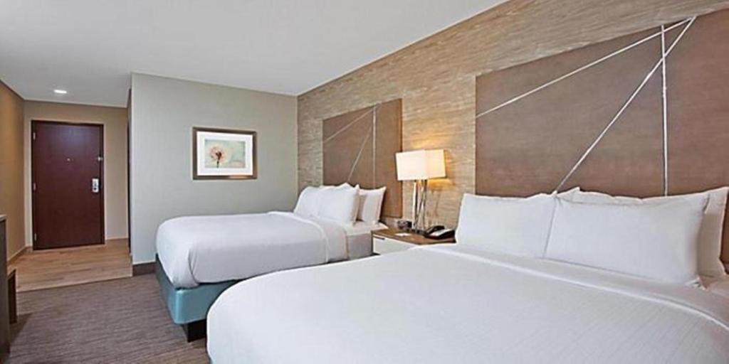 新坎伯兰新布劳恩费尔斯智选假日酒店 的配有两张床垫的酒店客房内的两张床
