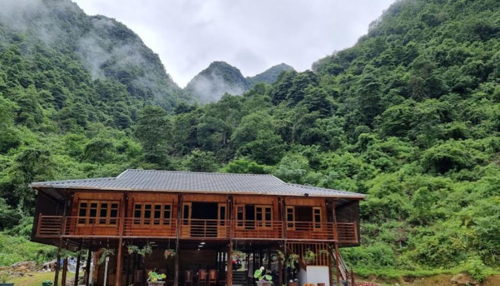 高平Tày Homestay Pác Bó - Cao Bằng的山前的木结构建筑