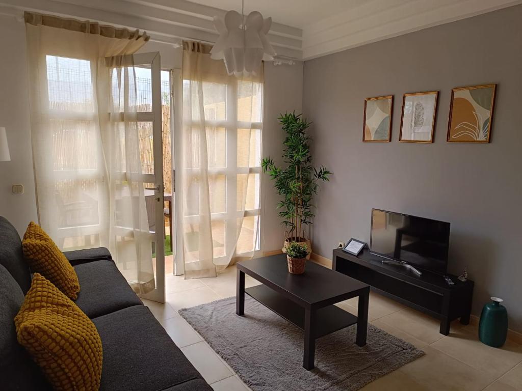 阿德耶Apartamentos ORLANDO en Costa Adeje的客厅配有沙发和桌子
