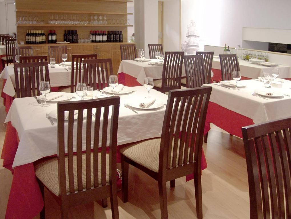 列尔加内斯Gastro Hotel La Giraldilla的用餐室配有白色桌椅和酒杯