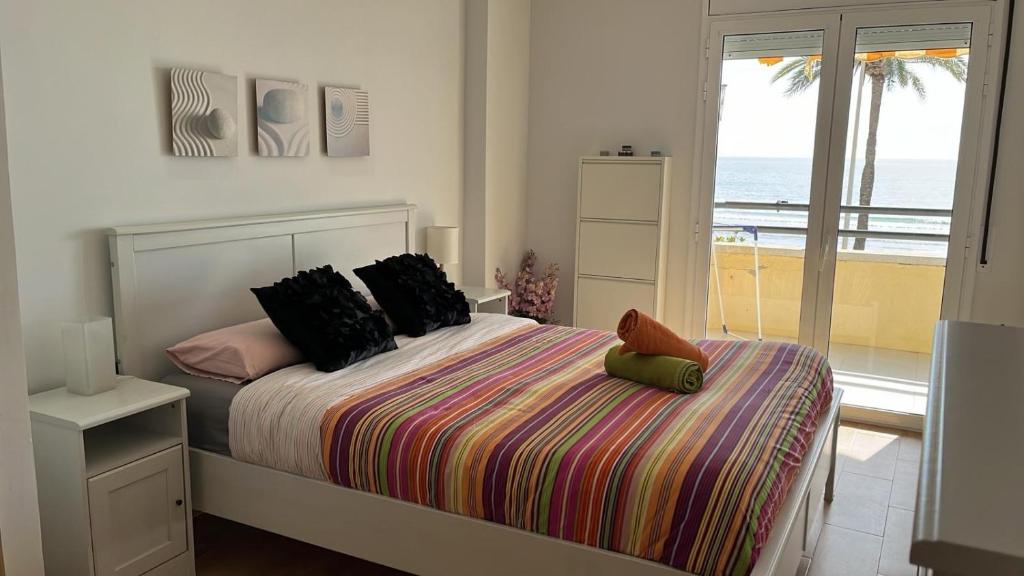 库尼特Apartamento Primera Linea de Mar, Cunit的一间卧室设有一张床,享有海景