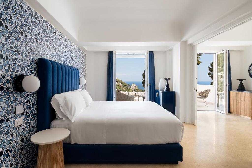 卡普里La Residenza Capri的卧室配有白色的床和蓝色的墙壁