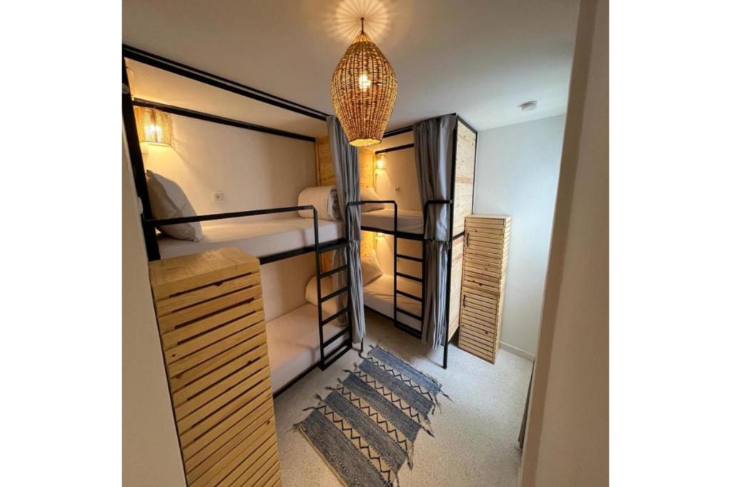 丹吉尔Socco Hostel的客房设有三张双层床和吊灯。