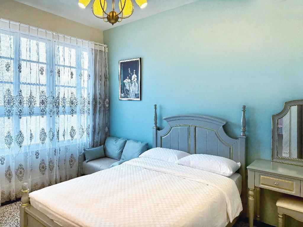 安平区朗香洋房 法式老洋房 台南民宿684編號的蓝色卧室,配有床和椅子