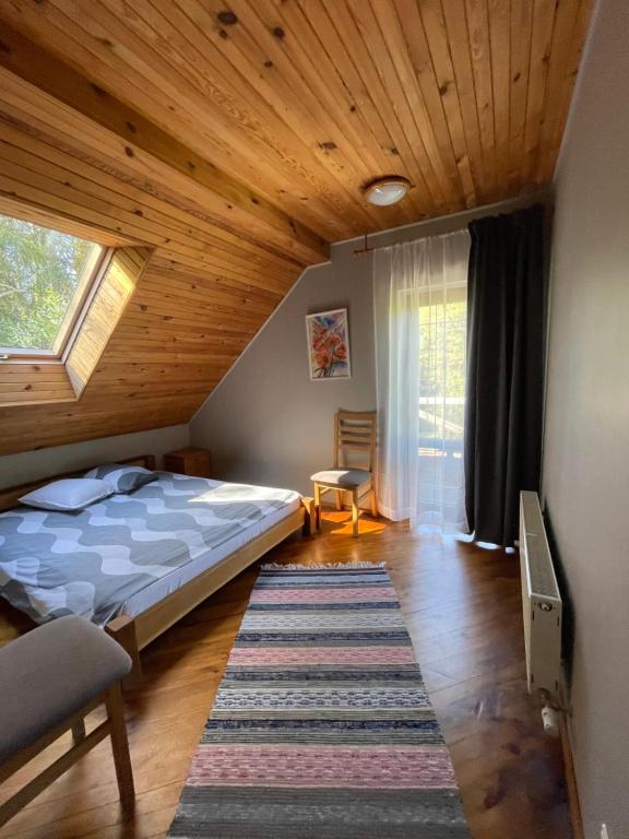坎达瓦卡克里酒店的一间卧室设有一张床和木制天花板